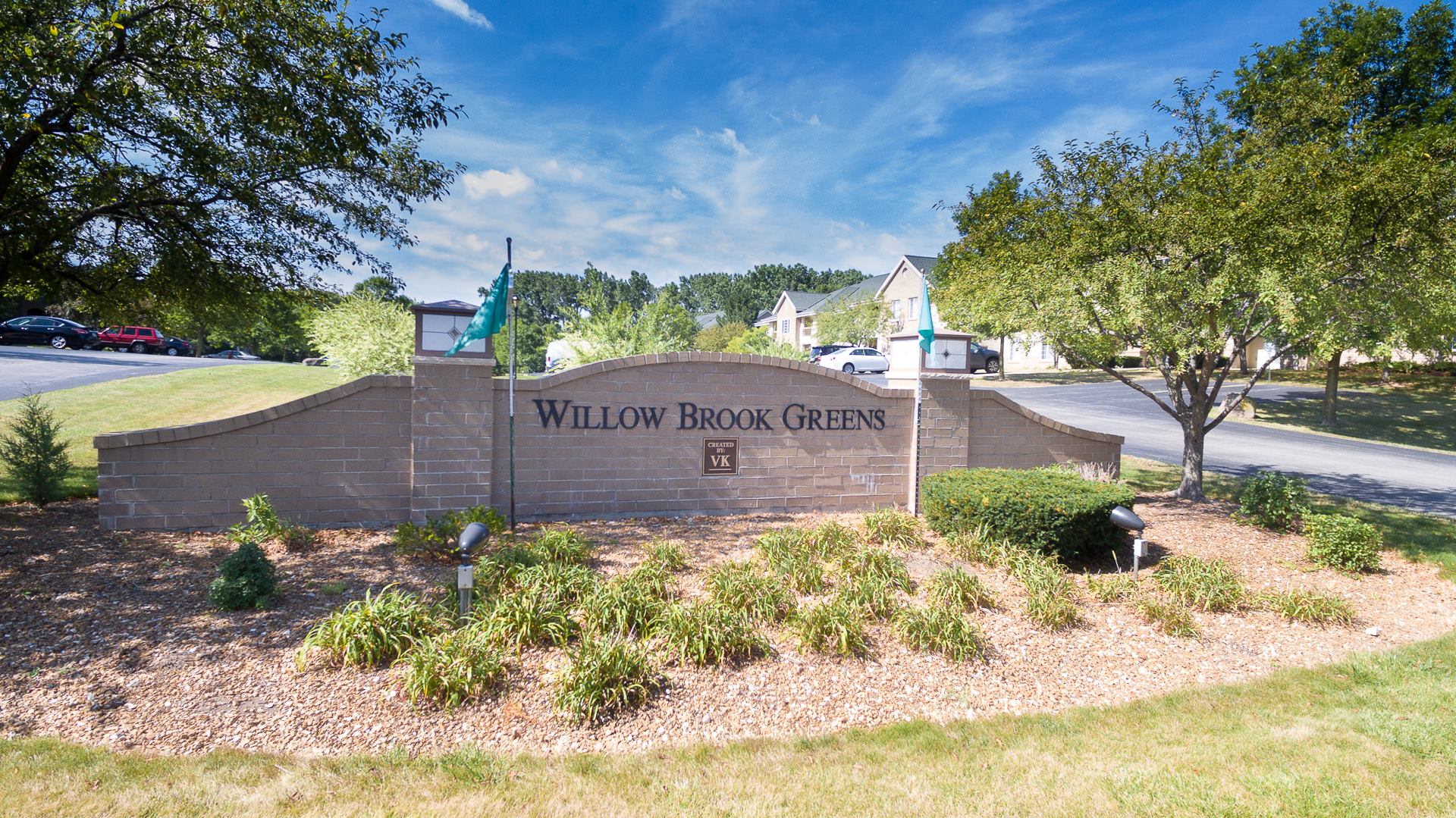 Aerial view of Willow Brook Greens apartments surrounded by mature trees on a sunny day